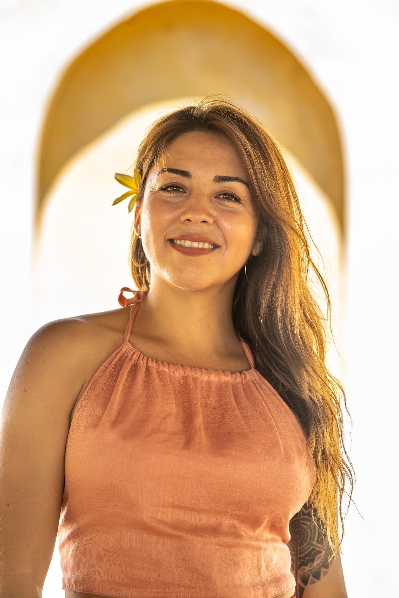 Javiera, founder of Hikari, smiling beneath a sunlit arch